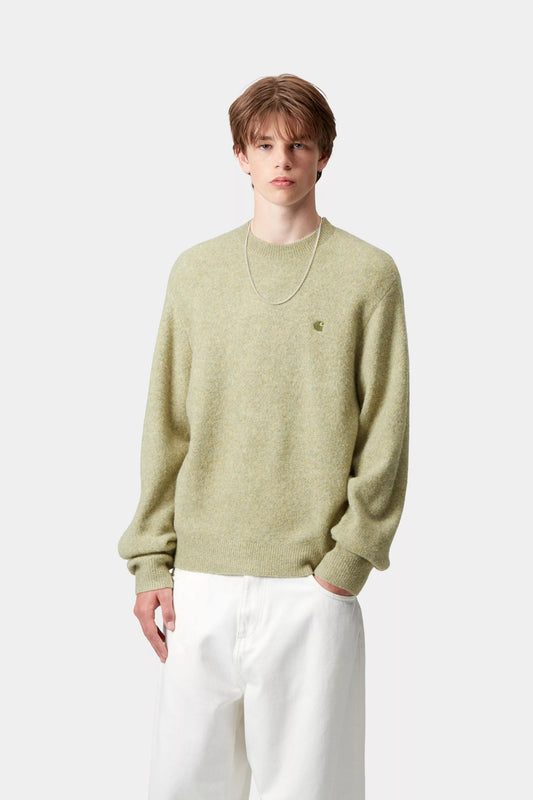 Person wearing a light green sweater and white pants on a white background