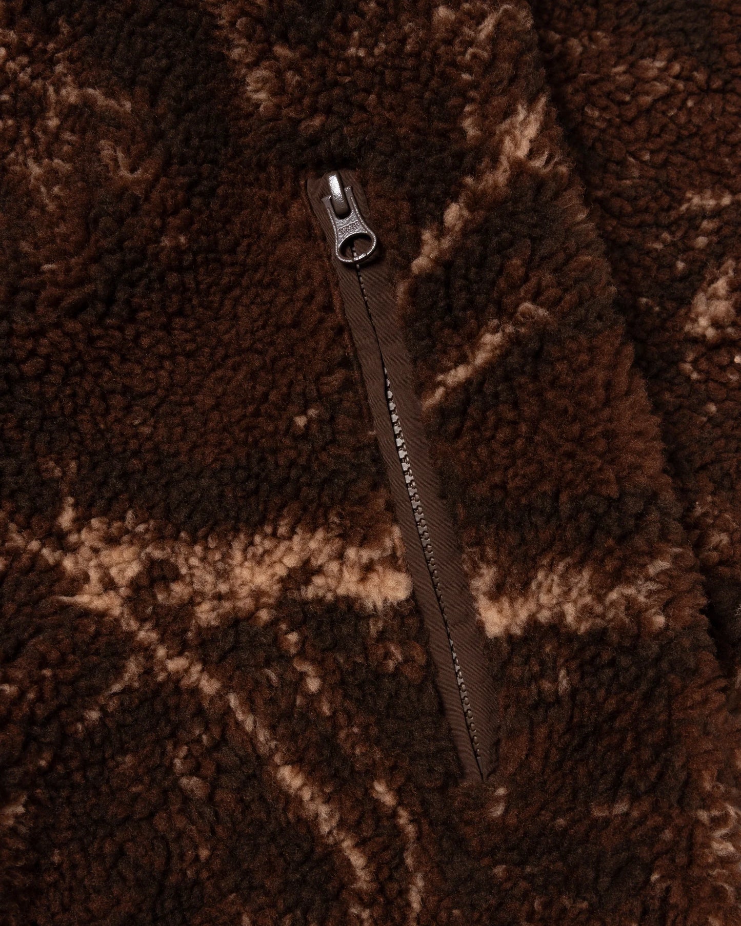 Close-up of a zipper on a brown textured fabric background
