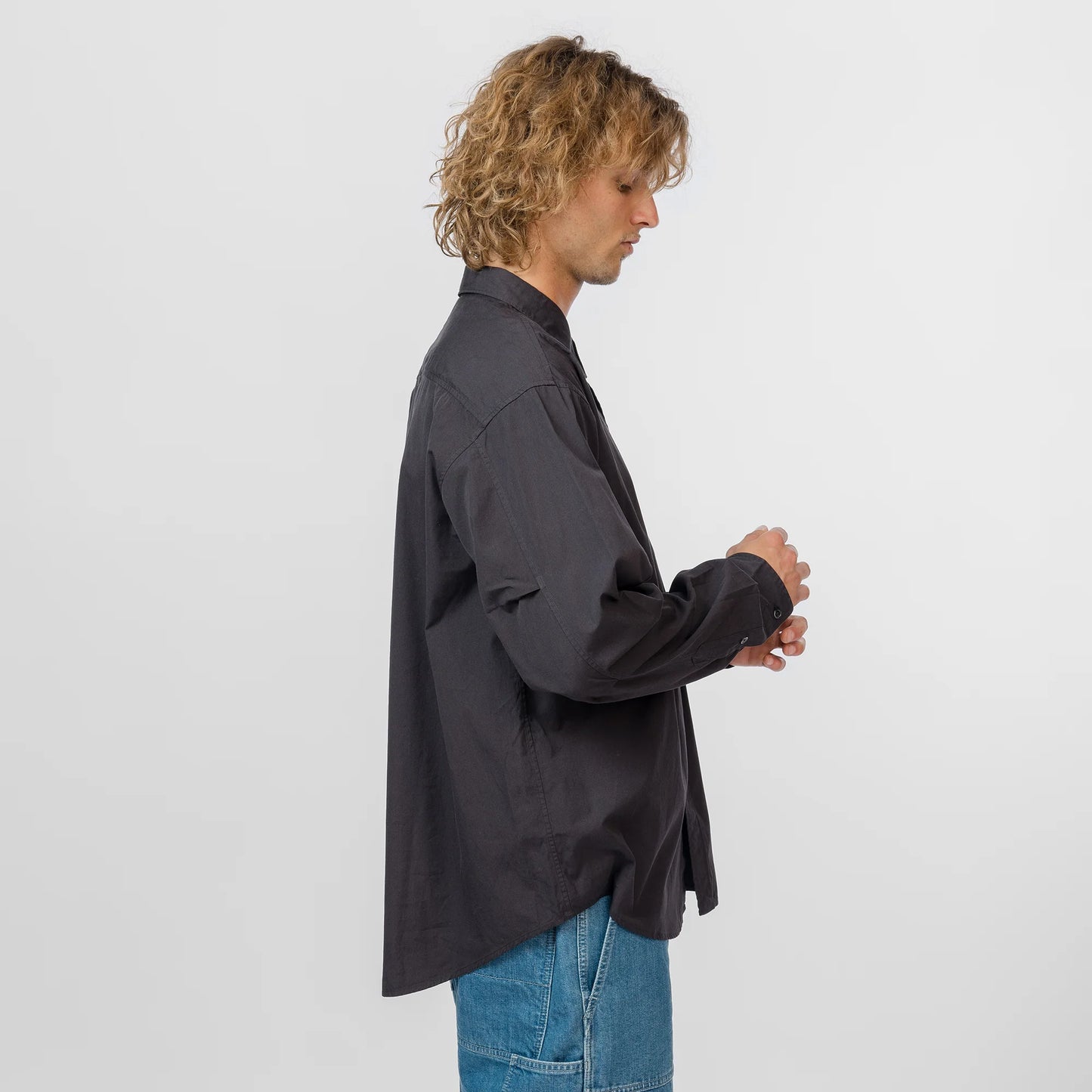 Person wearing a black shirt and blue jeans on a white background