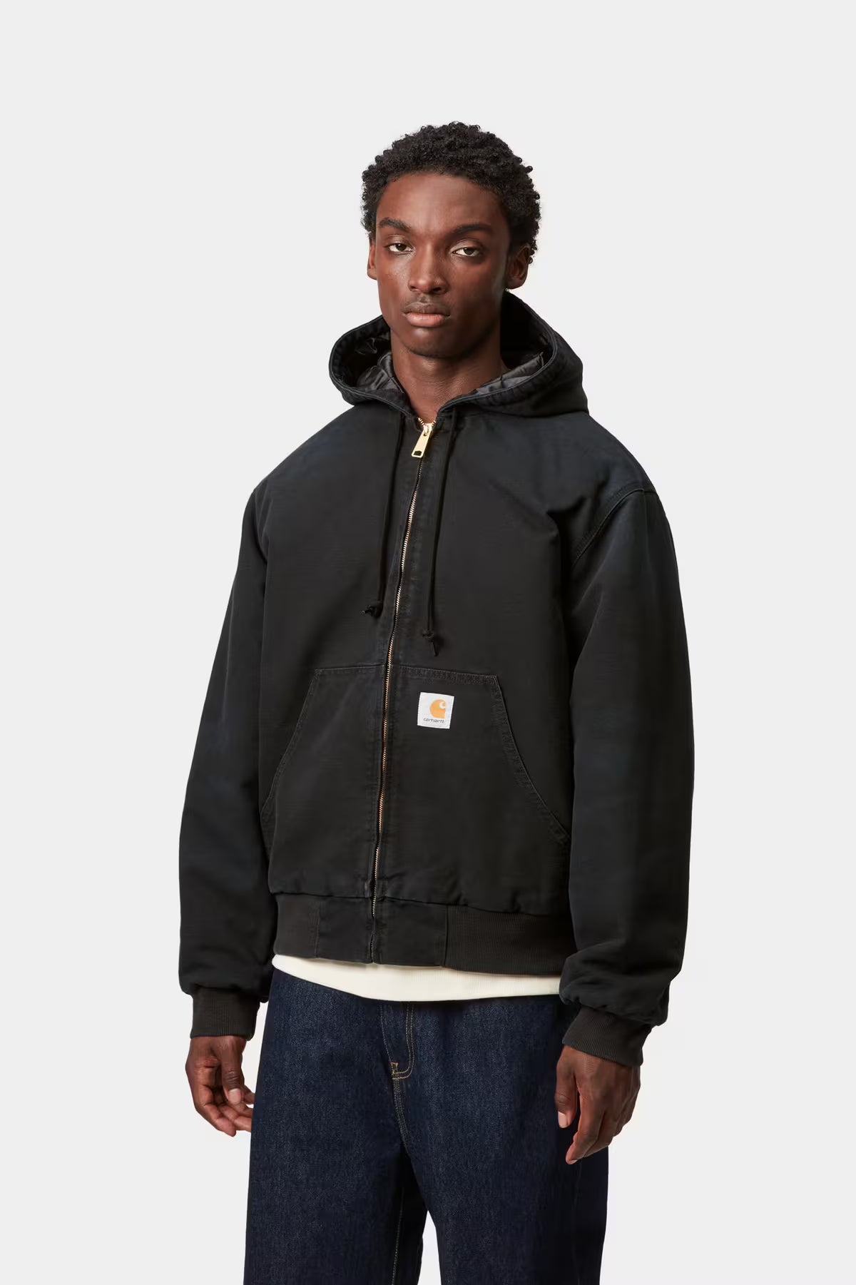 Person wearing a black hoodie with a visible brand logo on a white background