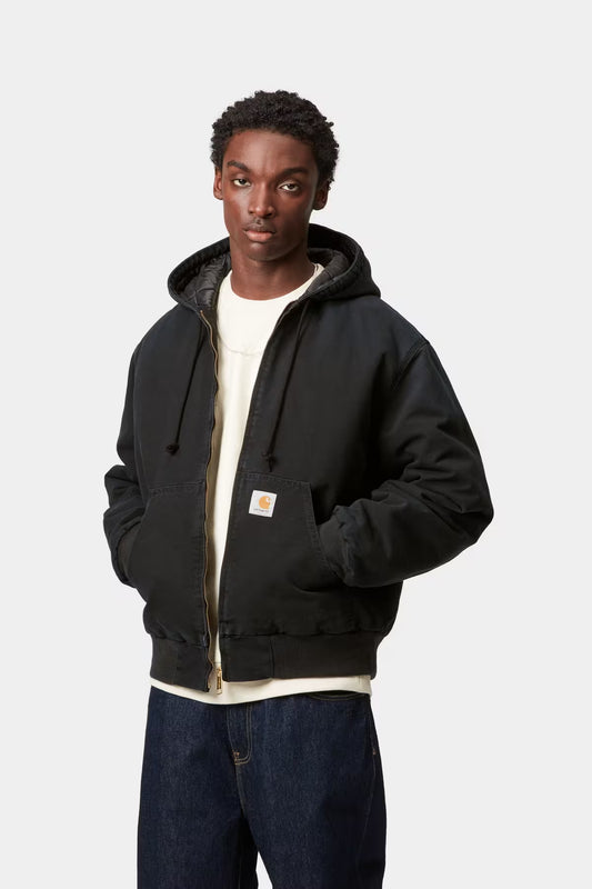 Man wearing a black jacket with a visible brand logo on a white background