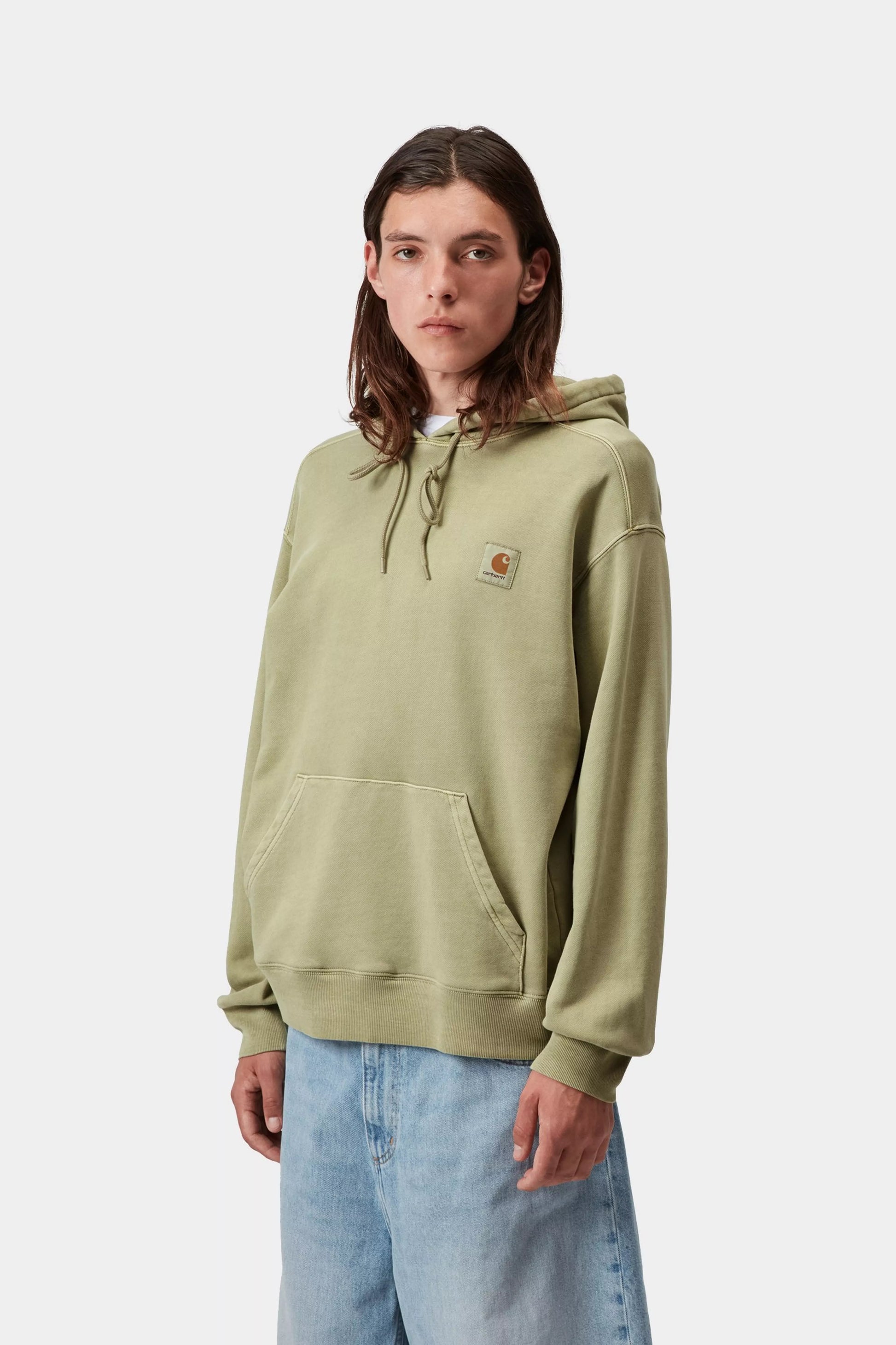 Person wearing a light green hoodie with a brand logo on a white background