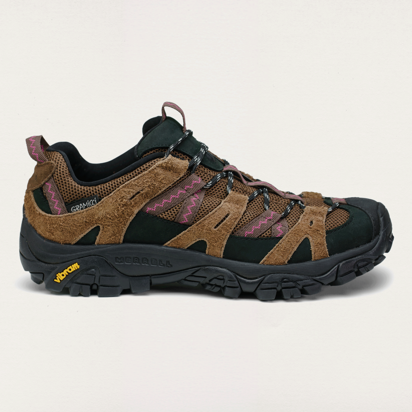 Brown and black hiking shoe on a light beige background