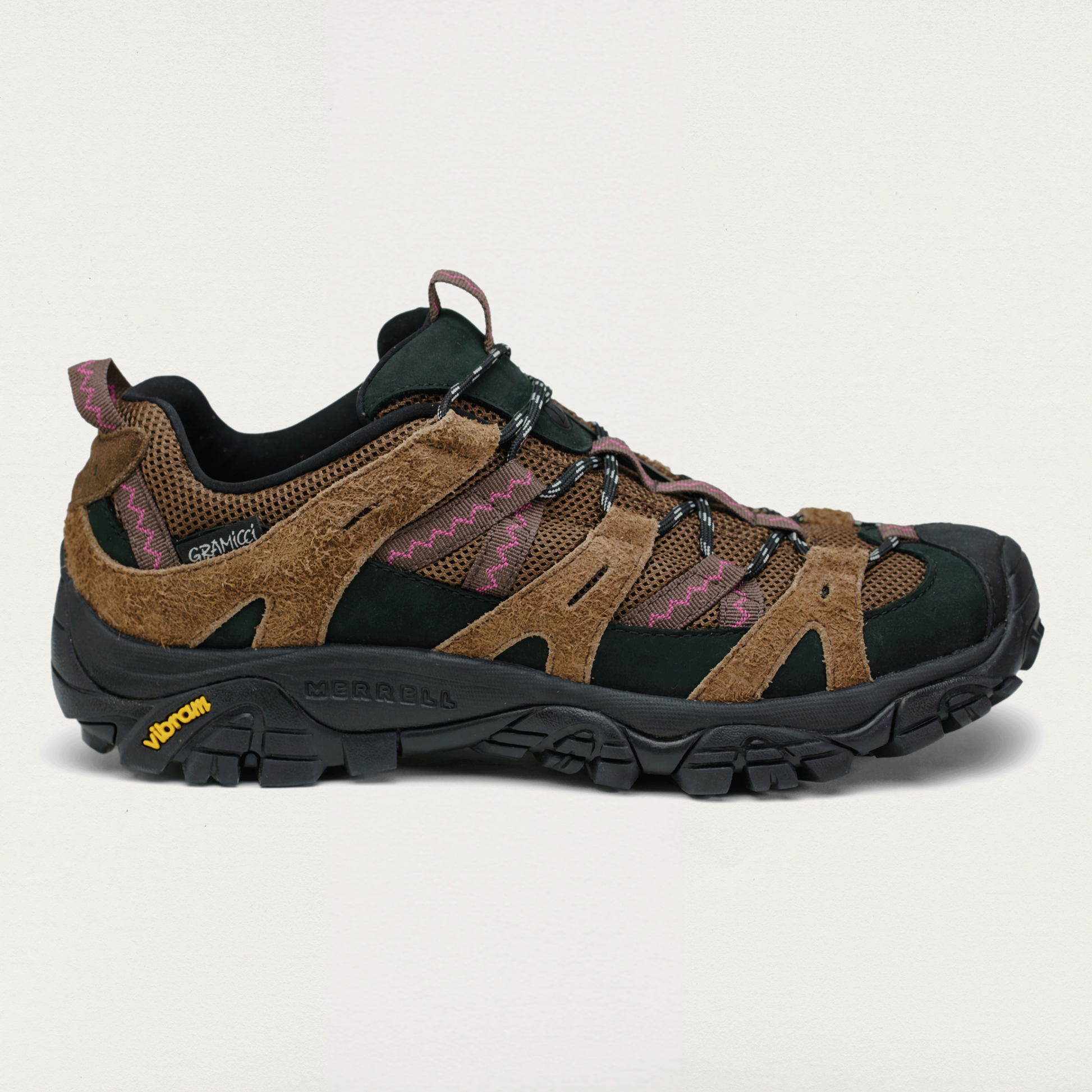 Brown and black hiking shoe on a light beige background