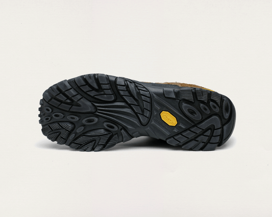 Close-up of a black shoe sole with a yellow label on a light gray background
