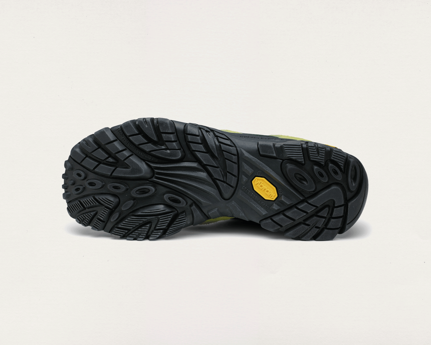 Black hiking boot sole with a yellow label on a light gray background