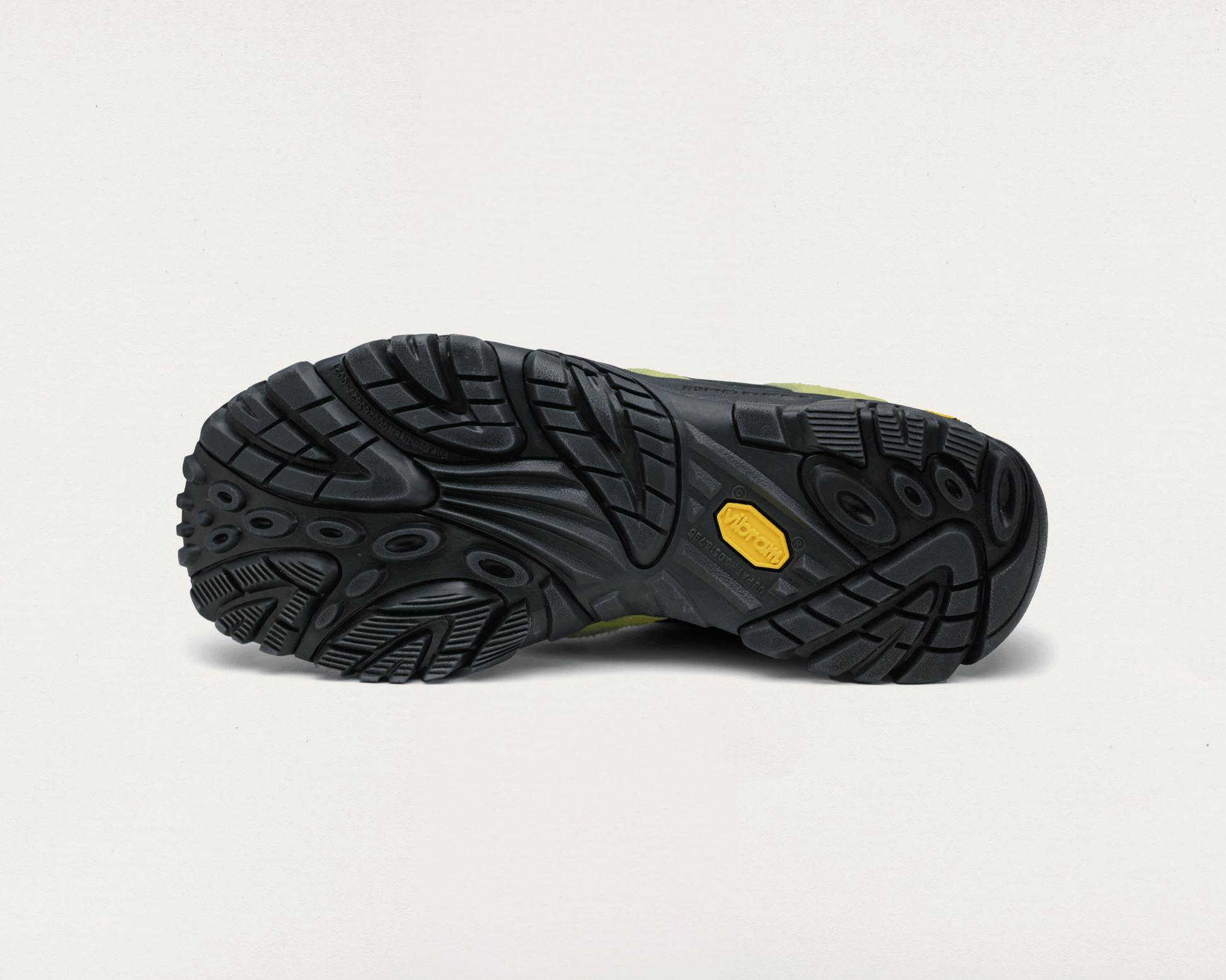 Black hiking boot sole with a yellow label on a light gray background