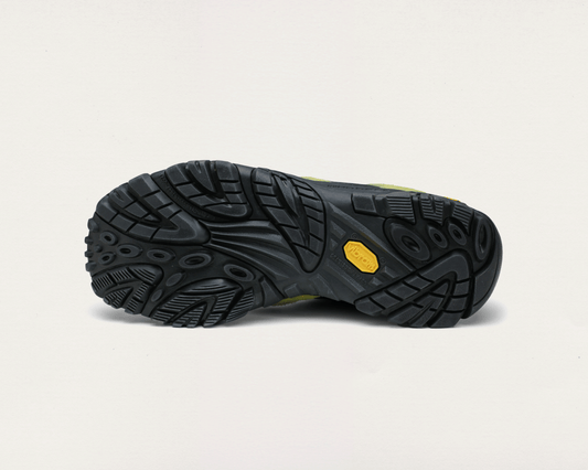 Black hiking boot sole with a yellow label on a light gray background