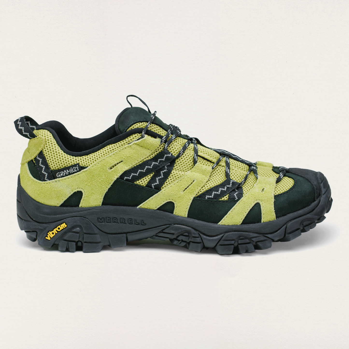 Green and black hiking shoe on a light gray background