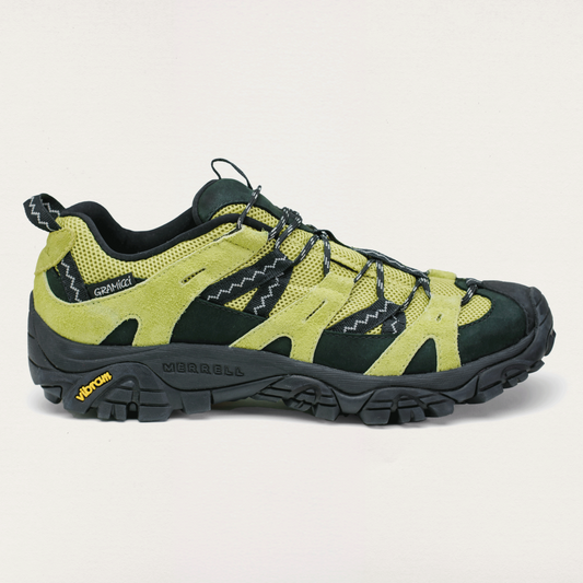 Green and black hiking shoe on a light gray background