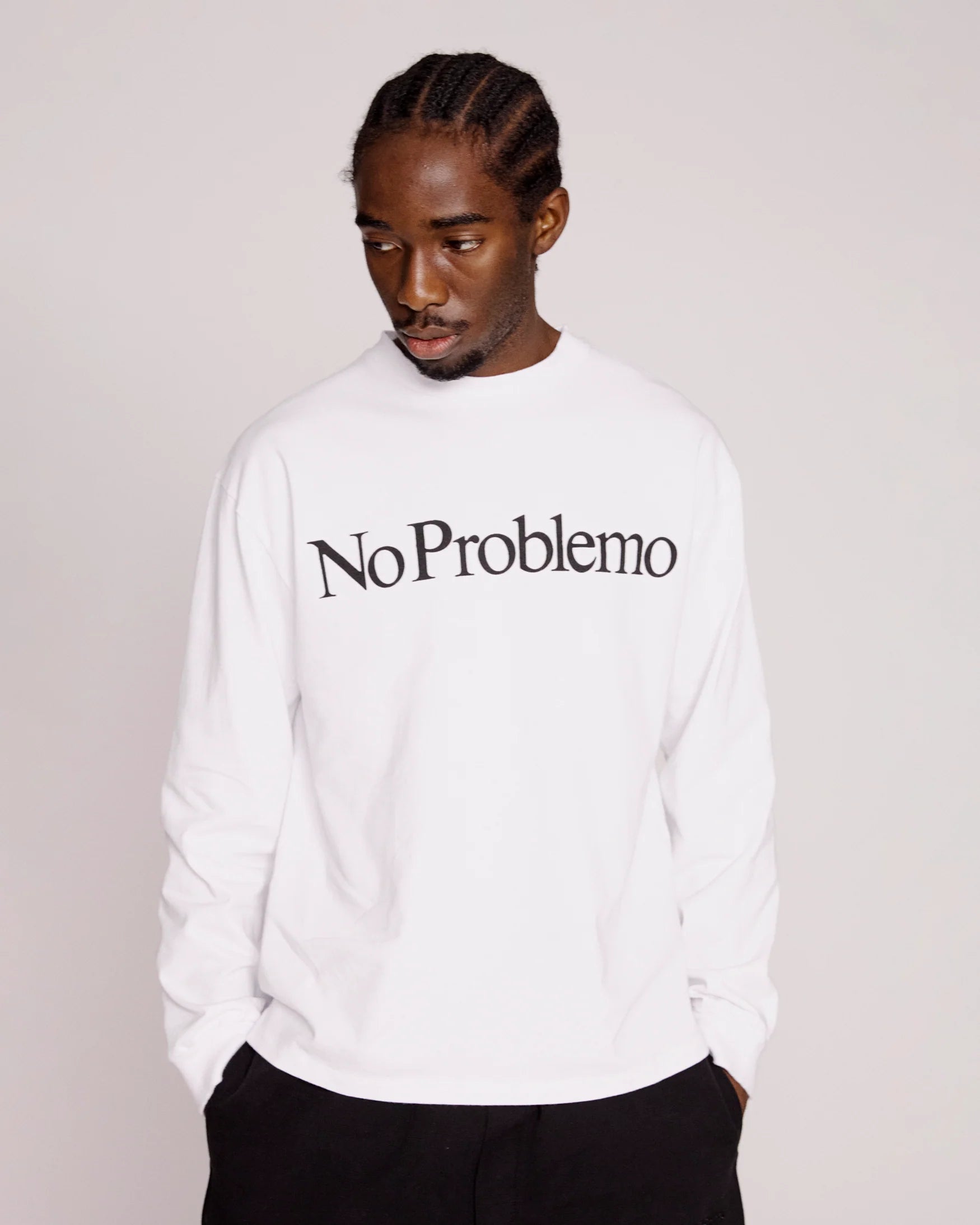 Person wearing a white sweatshirt with 'No Problemo' text on a plain background