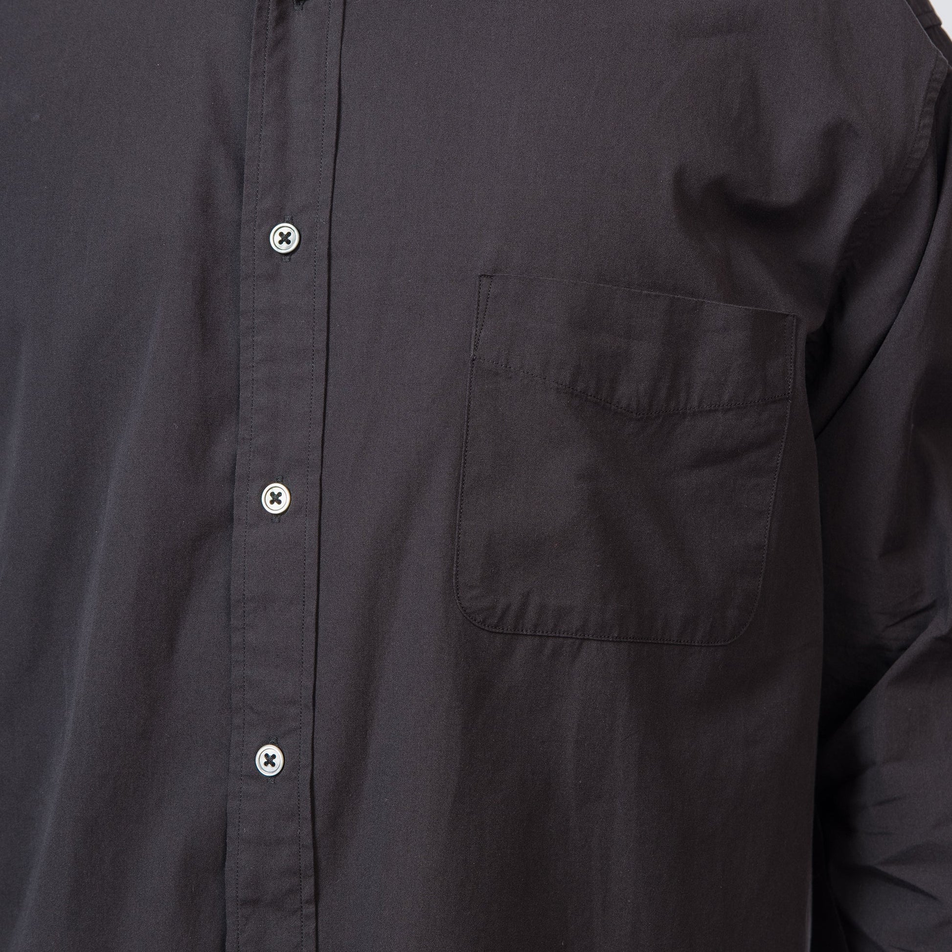 Close-up of a black button-up shirt with a pocket on a white background