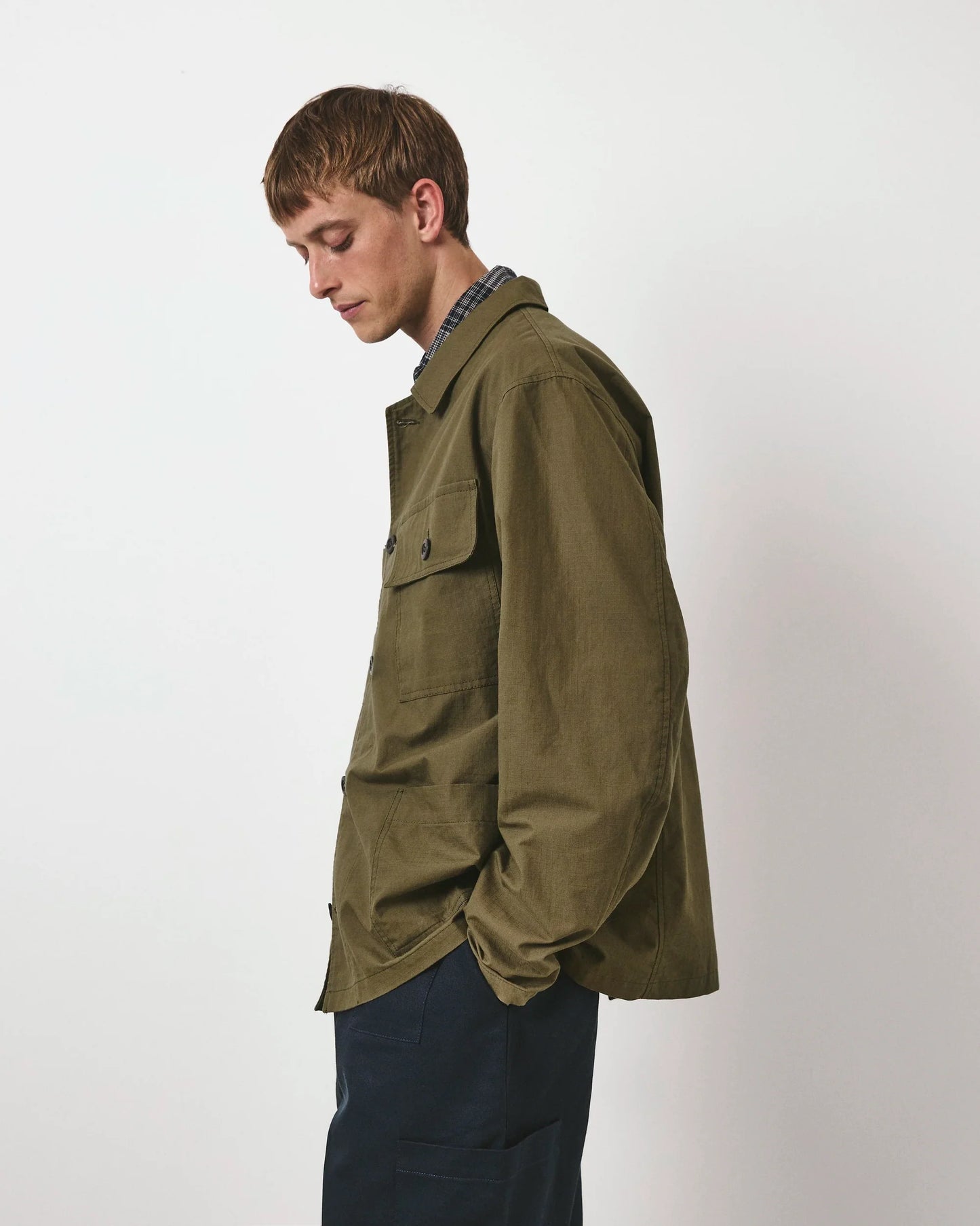 Person wearing an olive green jacket on a white background