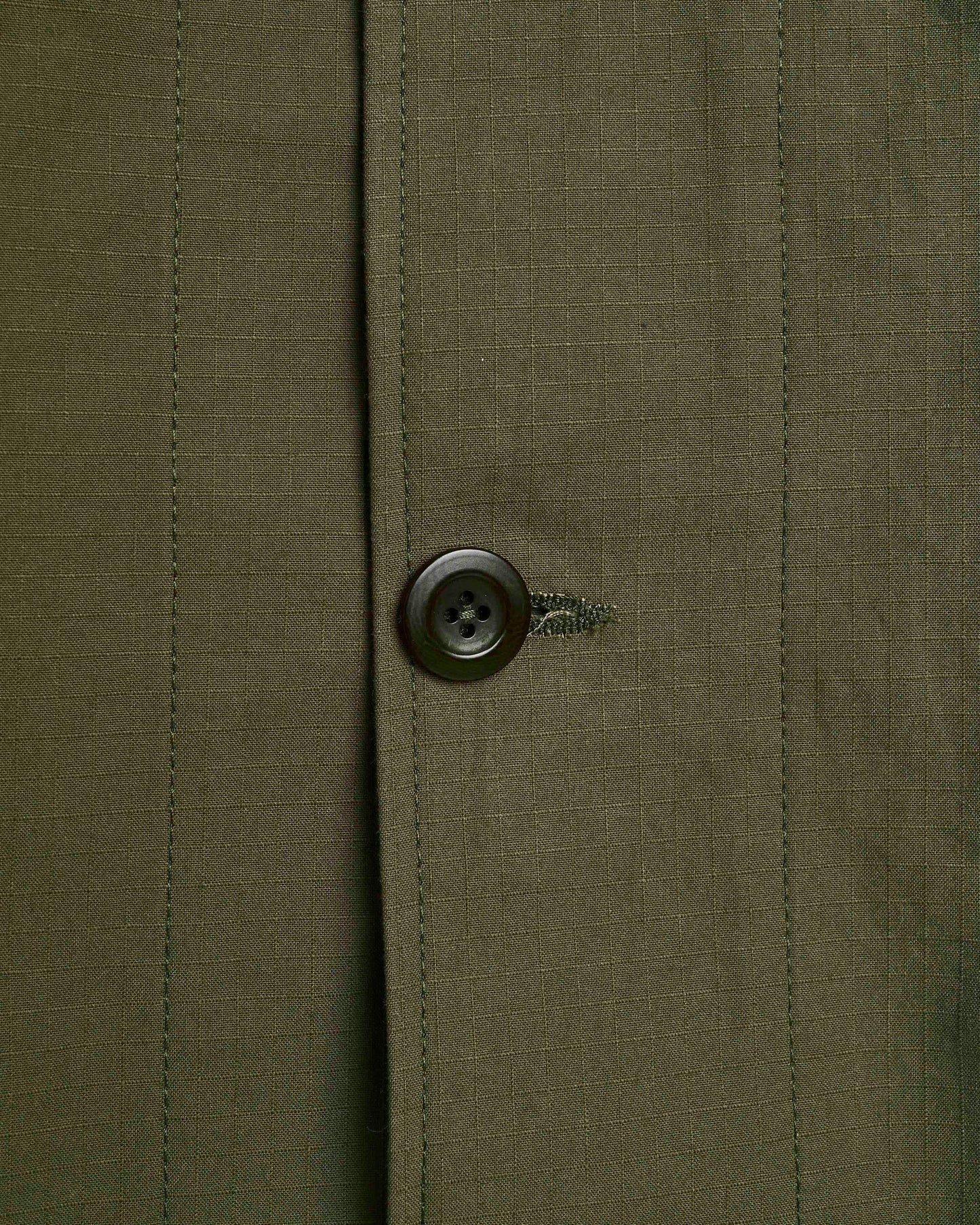 Close-up of a button on a green fabric background