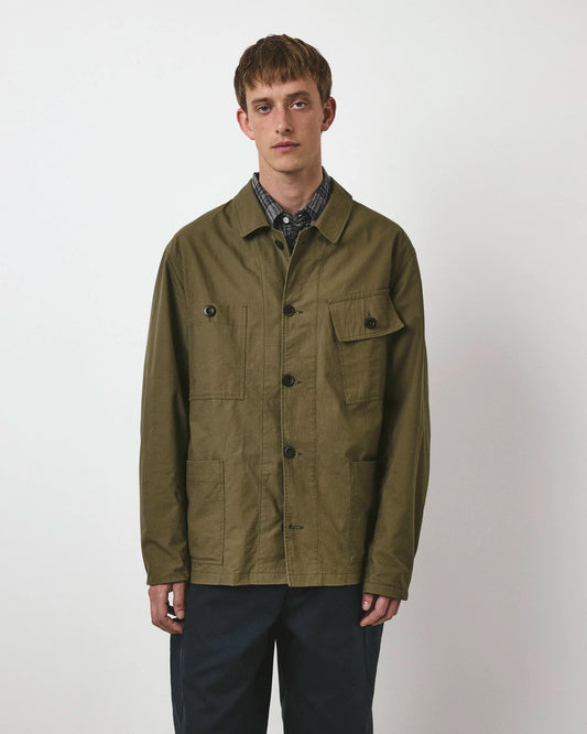 Man wearing a green jacket over a plaid shirt on a white background